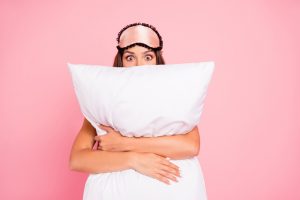 Young,Gorgeous,Shocked,Lady,Wearing,Eye,Mask,,Hugging,Pillow,,Hiding.